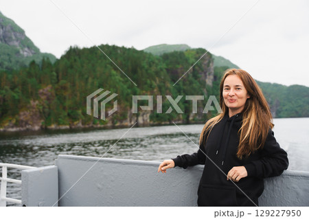 Woman with air touch hair on ferry in Norwegian fjord near Bergen. 129227950
