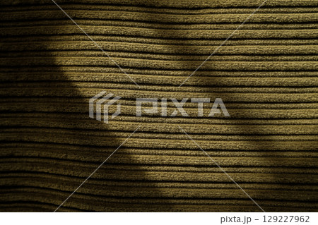 Corduroy fabric texture with horizontal ribbed pattern and dramatic shadows. 129227962