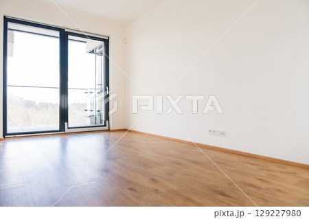 Modern empty room with tilt and turn windows and wooden flooring Modern empty room with tilt and turn windows and wooden flooring 129227980