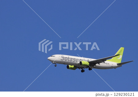 青空を背景に着陸する旅客機　着陸進入するソラシドエアー機 129230121