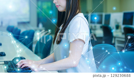 　パソコン教室でタイピングをする女子学生 129230688