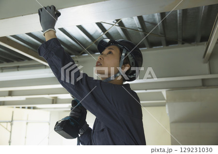 建築現場で働く若い女性作業員 129231030