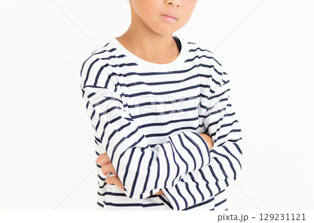 腕組みをして悩む小学生の男の子 129231121