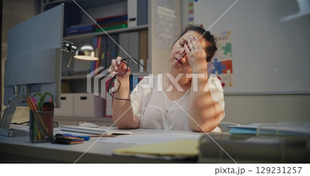 Tired Female Teacher Sitting at Computer in Empty Classroom, Feeling Stress, Burnout 129231257
