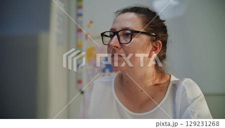 Primary School Teacher Working at PC in Classroom in the Evening Primary School Teacher Working at PC in Classroom in the Evening 129231268