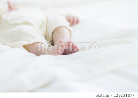 ベッドに寝転ぶ赤ちゃん ベッドに寝転ぶ赤ちゃん 129231877
