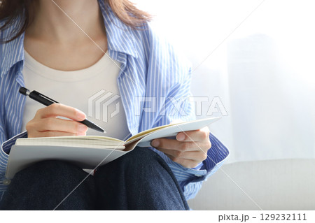 手帳とぺんを持った女性 129232111