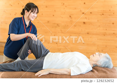 シニア女性をマッサージするあん摩マッサージ指圧師・理学療法士の女性 シニア女性をマッサージするあん摩マッサージ指圧師・理学療法士の女性 129232652