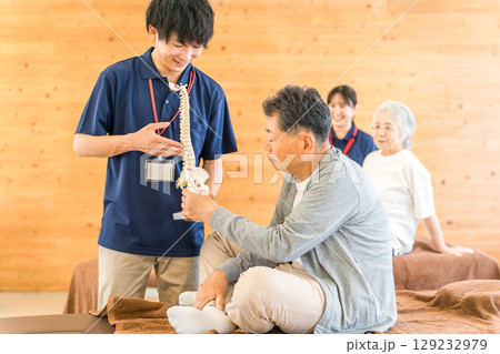 シニア男性に骨格標本で説明する理学療法士の男性スタッフ(リハビリ・スポーツ整形外科・トレーナー) シニア男性に骨格標本で説明する理学療法士の男性スタッフ(リハビリ・スポーツ整形外科・トレーナー) 129232979