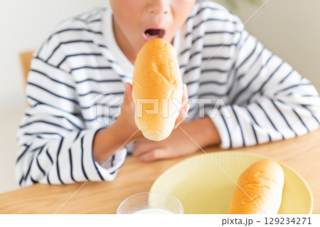 コッペパンを食べる小学生の男の子 129234271