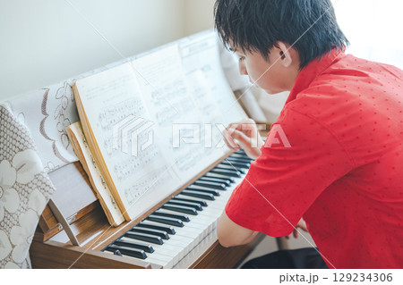 レトロなピアノオルガンと男性 129234306