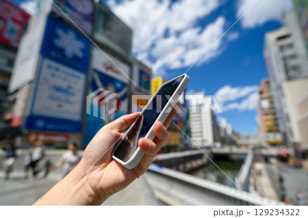 都会の屋外でスマホを掲げる手元 都会の屋外でスマホを掲げる手元 129234322
