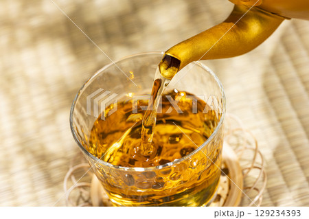 畳の上でやかんから麦茶をグラスに注ぐ和の涼を感じる夏 畳の上でやかんから麦茶をグラスに注ぐ和の涼を感じる夏 129234393