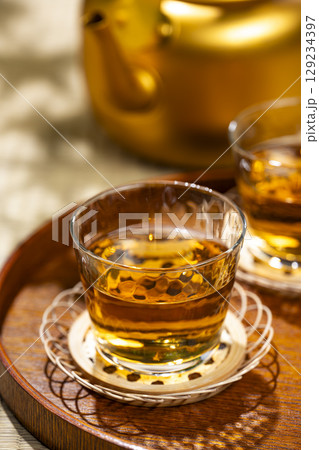 畳の上に置かれたお盆に並ぶ麦茶のグラスとやかん 畳の上に置かれたお盆に並ぶ麦茶のグラスとやかん 129234397
