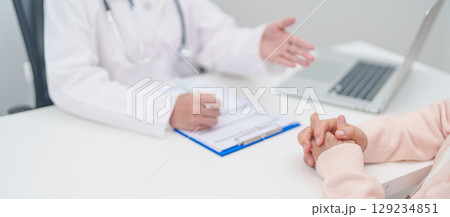 senior woman consulting with doctor in hospital. Elderly patient talking and sharing disease. Doctor listens, asking question and taking note. medical consultation and geriatric Healthcare concept senior woman consulting with doctor in hospital. Elderly patient talking and sharing disease. Doctor listens, asking question and taking note. medical consultation and geriatric Healthcare concept 129234851