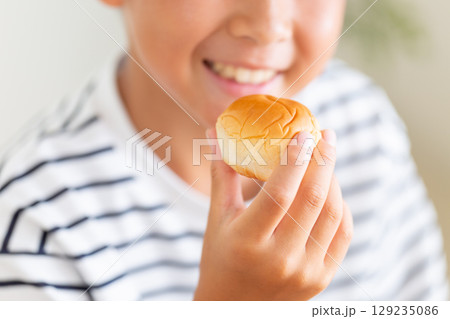 菓子パンを食べる小学生の男の子 菓子パンを食べる小学生の男の子 129235086