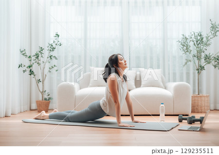 Young Asian woman stretching yoga workout on exercise mat Young Asian woman stretching yoga workout on exercise mat 129235511