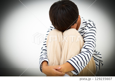 部屋に引き篭もって落ち込む小学生の男の子 129235607
