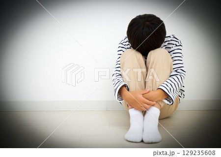 部屋に引き篭もって落ち込む小学生の男の子 129235608