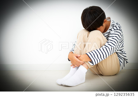 部屋に引き篭もって落ち込む小学生の男の子 部屋に引き篭もって落ち込む小学生の男の子 129235635