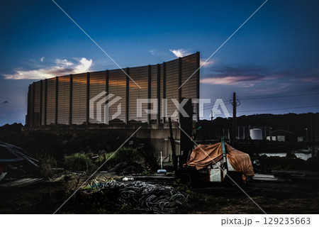 ＜素材＞夕暮れの暗い漁港放置された重機 129235663