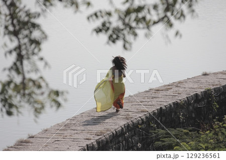 Graceful Indian Woman Draped in Traditional Saree 129236561