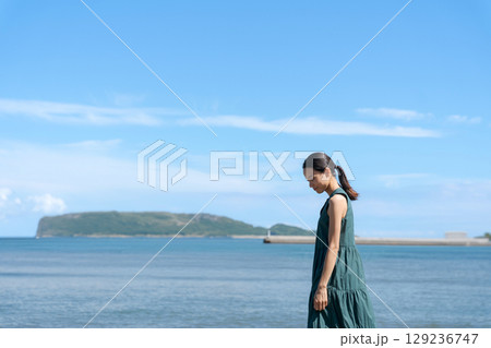 青い海に立つ若い女性 129236747