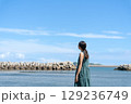 青い海に立つ若い女性 129236749