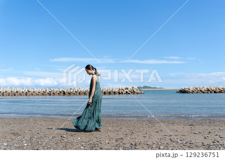 青い海に立つ若い女性 129236751
