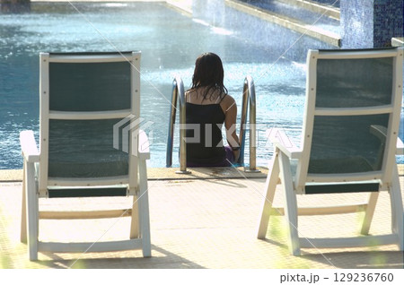 Female in Swimming pool at resort Female in Swimming pool at resort 129236760