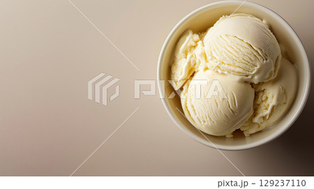 Three scoops of vanilla ice cream in white bowl on beige background, creamy dessert served in minimalist composition. 129237110