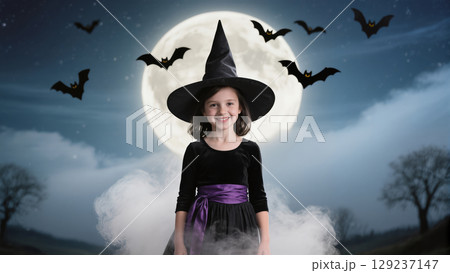 Halloween girl in witch costume smiling under full moon with flying bats and mist in spooky night atmosphere 129237147