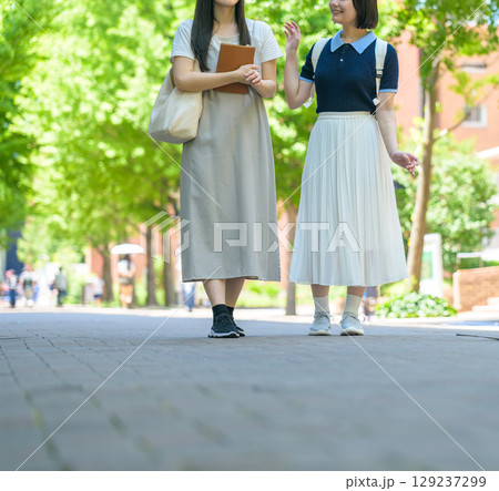 　木陰のキャンパスを歩く女子学生 129237299