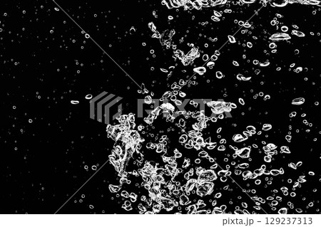 黒の背景に水中に舞い上がるたくさんの気泡. 129237313