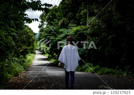 ＜素材＞森を孤独に一人歩く女性の後ろ姿 129237925