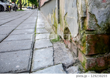 Old Brick Wall with Damaged Crumbling Facade at Street Level Old Brick Wall with Damaged Crumbling Facade at Street Level 129238203