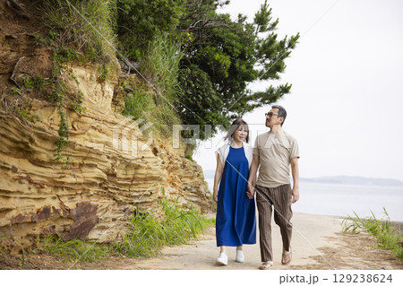 海岸沿いを歩く夫婦の後ろ姿 海岸沿いを歩く夫婦の後ろ姿 129238624