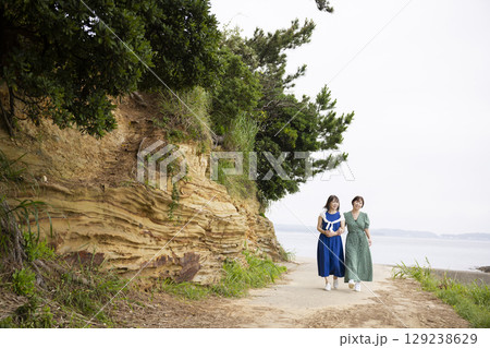 海岸沿いを歩く女性の後ろ姿 129238629