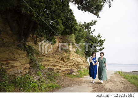 海岸沿いを歩く女性の後ろ姿 129238683