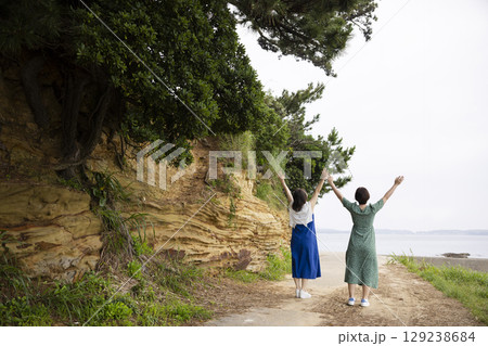 海岸沿いを歩く女性の後ろ姿 129238684