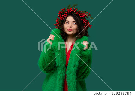 Woman in green coat and red berry wreath Woman in green coat and red berry wreath 129238794