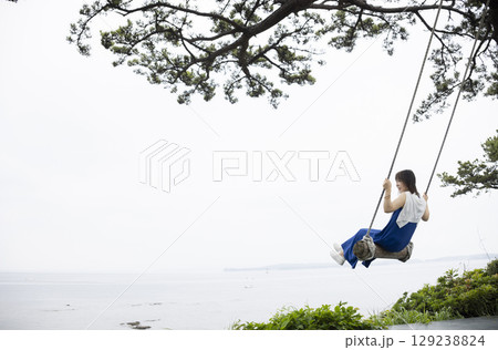 ブランコで遊ぶ女性 129238824