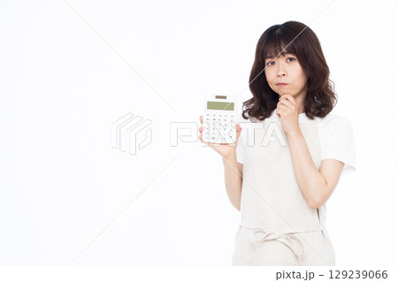 電卓を持って真剣に悩んでいる主婦 電卓を持って真剣に悩んでいる主婦 129239066