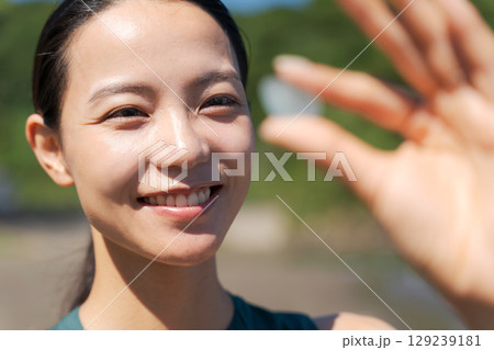 砂浜でシーグラスを拾う女性 129239181