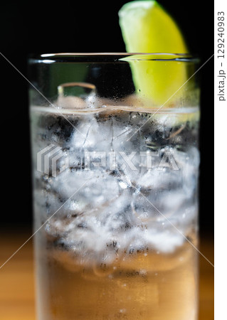 【カクテル素材】氷の入ったグラスに注がれた美味しそうなジントニック・黒バック【ドリンク素材】 129240983