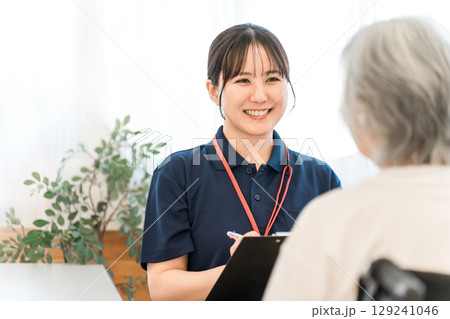 シニア女性をカウンセリングする理学療法士,作業療法士の女性スタッフ 129241046
