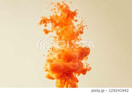 A vibrant orange ink explosion creates a dynamic, captivating texture across the frame 129241942