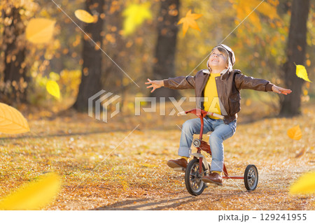 Happy child having fun outdoor in autumn park Happy child having fun outdoor in autumn park 129241955