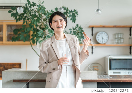朝食,間食でプロテインバー,栄養バーを食べるスーツ姿の若いアジア人女性 129242271
