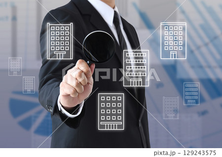 虫眼鏡を使って企業の研究を行うビジネスマン 虫眼鏡を使って企業の研究を行うビジネスマン 129243575